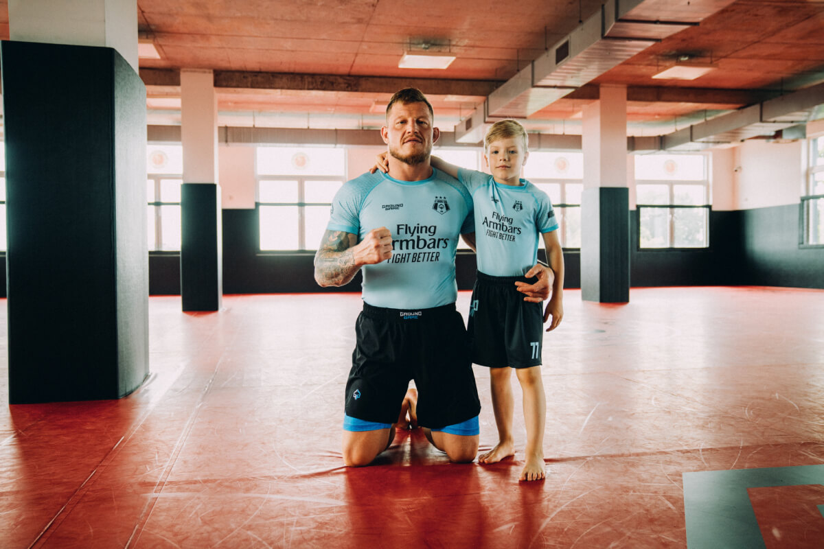 Părinte care își susține copilul la antrenament de arte marțiale